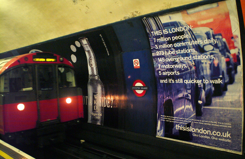 A very amusing advertising billboard highlights some of London's traffic problems as a train pulls into Leicester Square tube / subway station.  London, U.K..